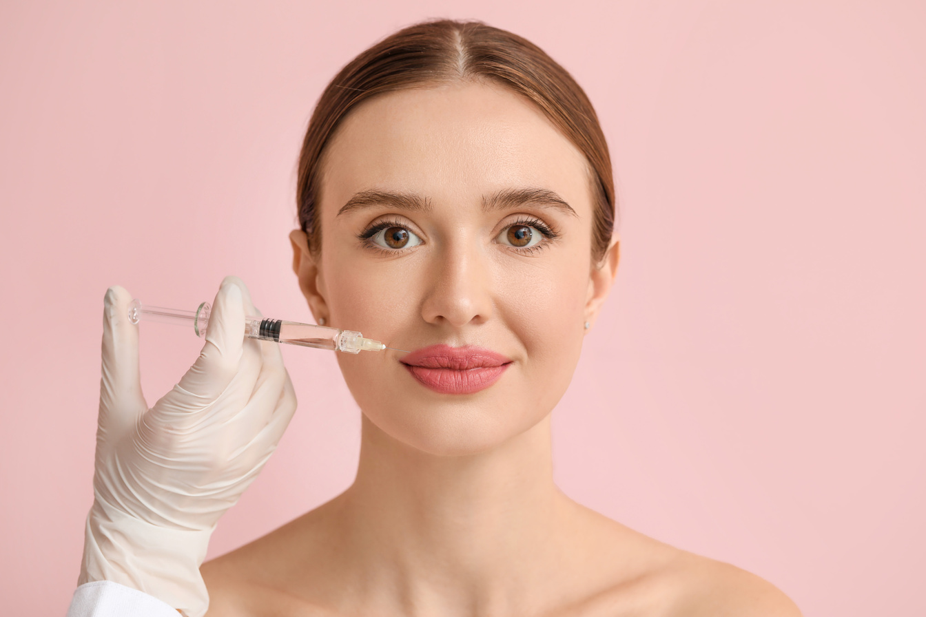 Young Woman Receiving Filler Injection against Color Background